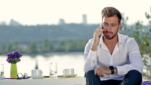 Hombre guapo hablando por teléfono al aire libre