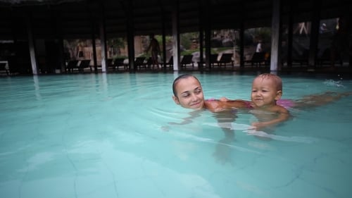 Mutter hat Spaß mit kleinen Mädchen im Pool.