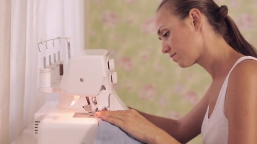 Young Woman Sews On The Sewing Machine