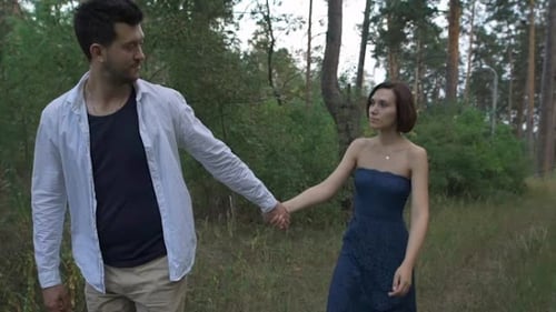 A Pleasant Man With a Beard Leads His Beautiful Wife Or Girl On a Footpath In The Woods.