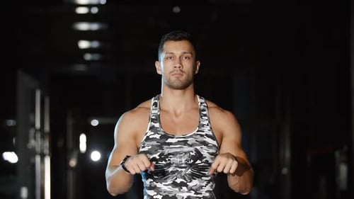 Athletic Man Works out Stretches Wrists Rotates Low Back Gym