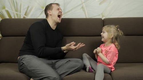 Father and Daughter Playing Hand Game at Home