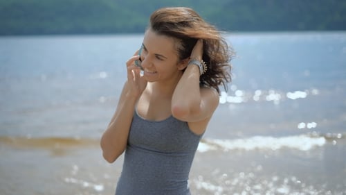 A Young Beautiful Woman Talking to Her Boyfriend Using Smartphone at a Beach