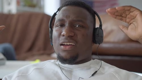Man Grooving to Music with Headphones Indoors