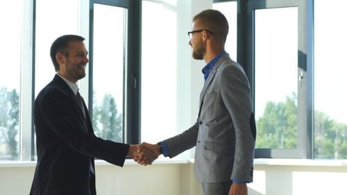 Two Businessmen Shaking Hands in Modern Office