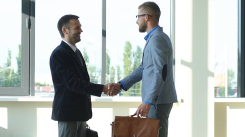 Two Men Meeting and Shaking Hands in Modern Office