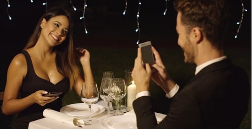 Stylish Couple on a Romantic Date Using Smartphones