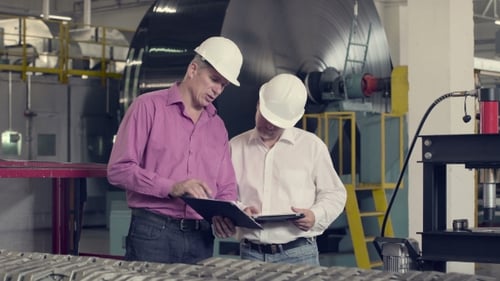 Engineers Reviewing Data in Industrial Manufacturing Plant