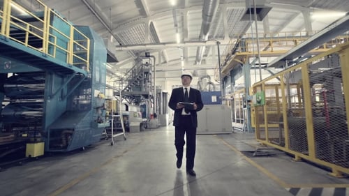 Geschäftsmann geht durch die Fabrik