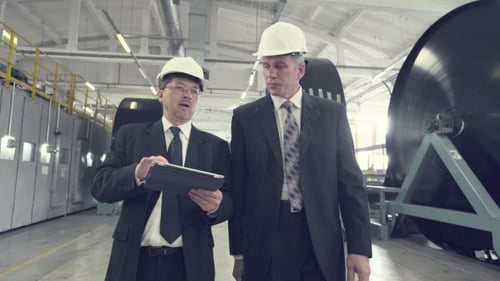 Two Businessmen Walking Through Factory