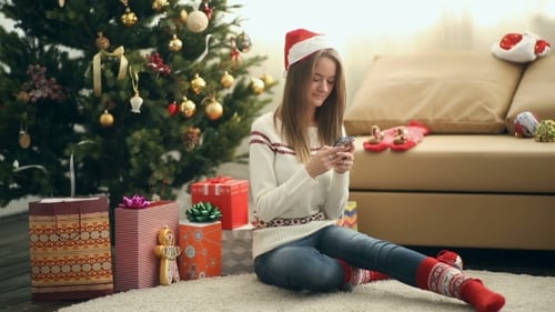 Pretty Girl In Christmas Cap Using Smartphone