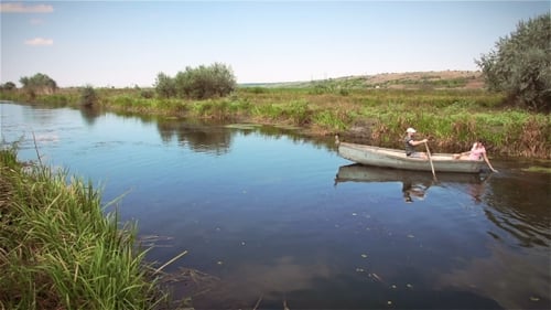 Couple Rowing Boat on Scenic Canal