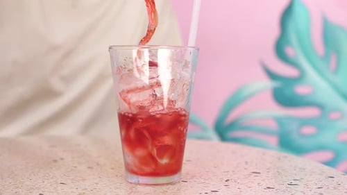 Red Juice Poured Over Ice into a Glass