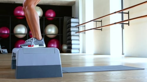 Woman Doing Step Jumps At The Gym.