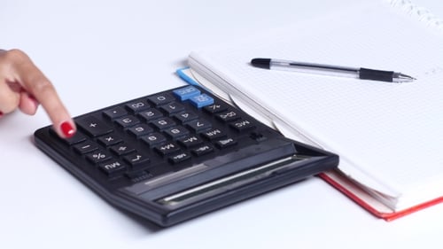 Girl Makes The Calculations And Writes The Numbers In a Notebook.