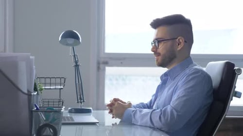 Young Man Video Conferencing at Bright White Desk