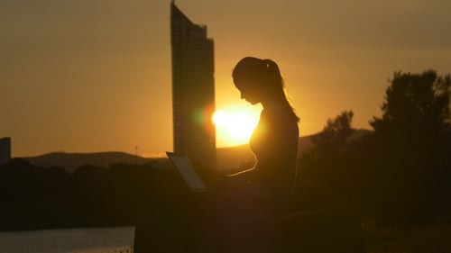 Wolkenkratzer, Sonne und Mädchen mit Laptop