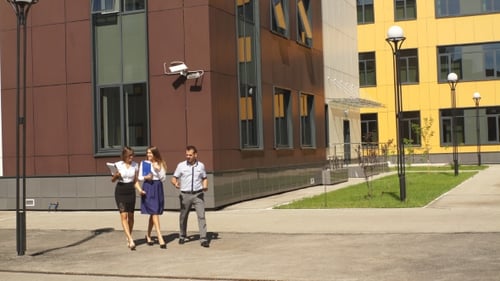 Three Colleagues Walk Through The Innovation Center And Communicate