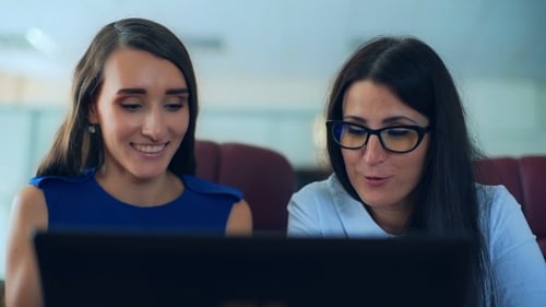 Two Women Collaborating on Laptop in Office