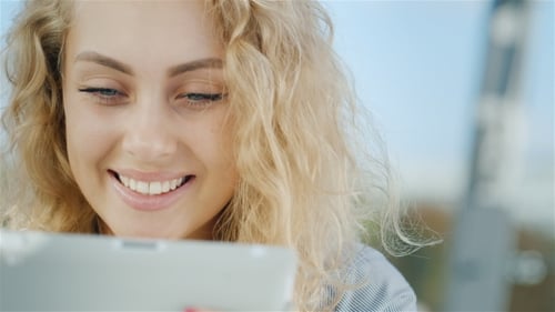 Portrait Of An Attractive Young Woman Uses Tablet, Smiling