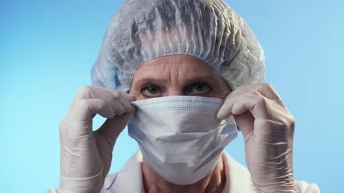 Woman putting on surgical mask