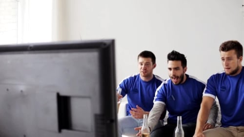 Three Men Cheer While Watching Sports on TV