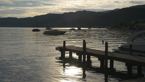 Peaceful Scenery Of Boats In Lake On Sunset
