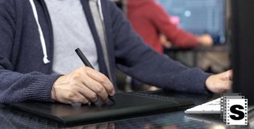 Graphic Designer Working at Computer with Tablet