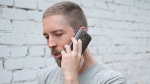 Bearded Man on Cell Phone Call Outdoors