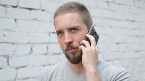 Young Adult with Beard Talking on a Cellphone