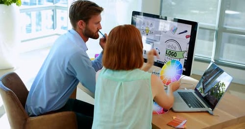 Designers Collaborating on Logo Design in Modern Office