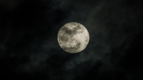 Ethereal Full Moon Through Drifting Clouds at Night