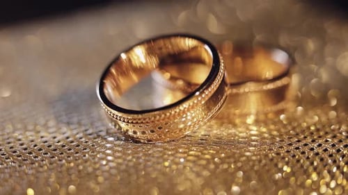 Golden Wedding Rings on Gold Sparkly Surface