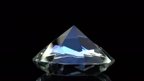 Diamond Slowly Rotates with a Sharp End Up. Black Background