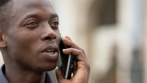 Relaxed american african young man talking by phone- close up