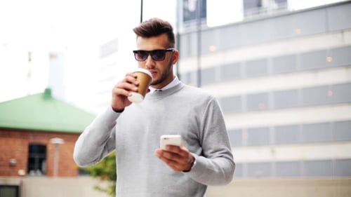 Man With Smartphone And Coffee Cup On City Street