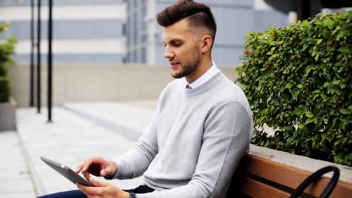 Man With Tablet Pc Sitting On City Street Bench