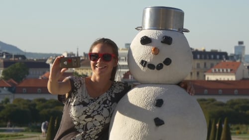 Chica fotografía selfie en un abrazo con un muñeco de nieve en Belvedere