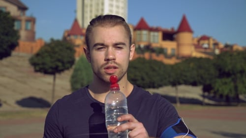 Man Drinking Water after Exercise Outdoors