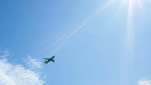 Large Passenger Plane Gaining Altitude After Takeoff in Front of the Bright Sun