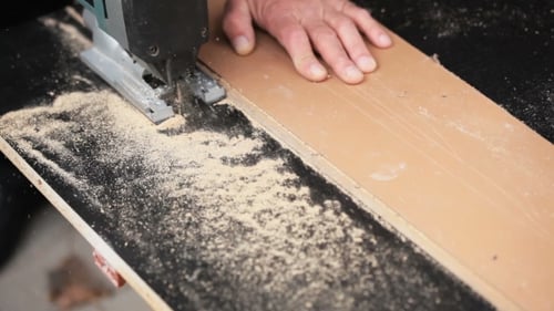 Man With Electric Jigsaw. Work Creates Furniture