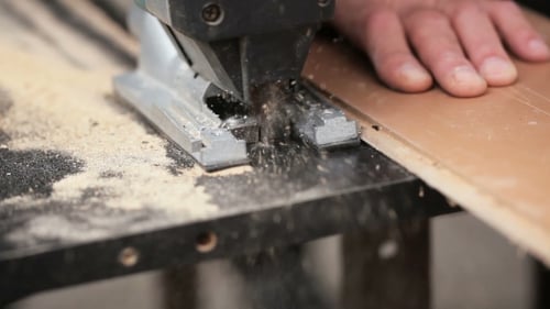 Man With Electric Jigsaw. Cutting Board.