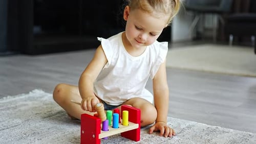 Cute Caucasian Little Girl Playing on the Floor at Home with Eco Wooden Toys