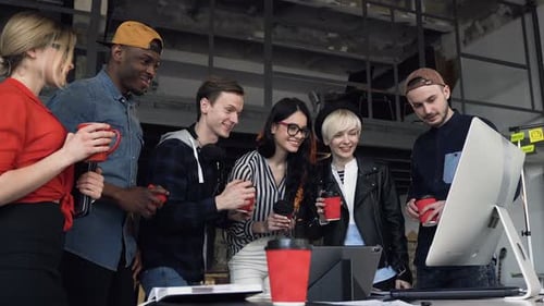 Groupe de six jeunes employés de bureau tintant une tasse de thé, café