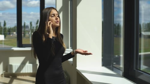 Woman Talking on Cell Phone in Office Building
