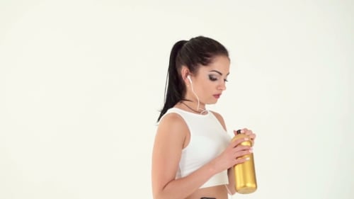 Woman Drinking Water from Gold Bottle after Workout
