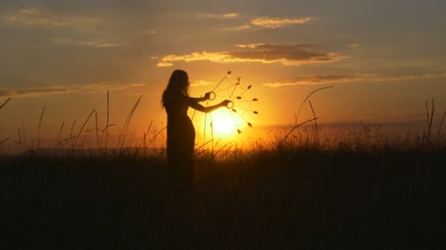 Woman Dancer Performs a Fire Show In Front Of The Sun