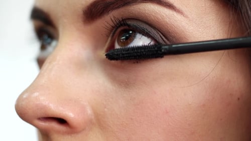 Woman Applying Mascara to Eyelashes Close Up