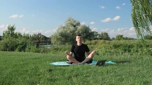 Man meditation. Male doing yoga exercises in park in morning