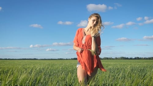 Beautiful Young Blond Woman With The Sexy Look Standing And Enjoying Herself At a Green Field